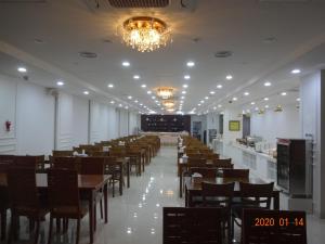 a dining room with tables and chairs and a chandelier at Ocean Grand Hotel in Jeju