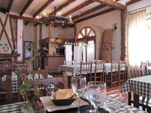 ein Restaurant mit Tischen und Stühlen mit Weingläsern in der Unterkunft Casa Rural de la Abuela in Montejo de Tiermes