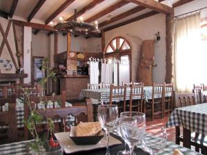 a restaurant with tables and chairs with wine glasses at Casa Rural de la Abuela in Montejo de Tiermes
