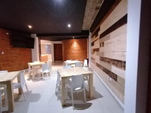a room with tables and chairs and a brick wall at Hotel NUMAY in Cajamarca