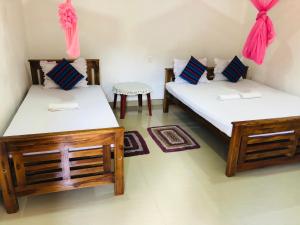 a room with two beds and a table at Kumari Guest House in Polonnaruwa