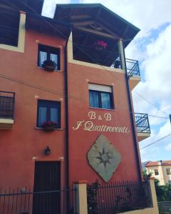un edificio rojo con un cartel en el costado en I Quattroventi, en Muravera