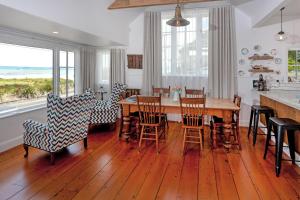 a kitchen and dining room with a wooden table and chairs at Kuranui Cottage in Thames