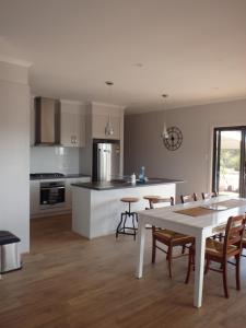 a kitchen and dining room with a white table and chairs at Gilligan's Kangaroo Island in Baudin Beach