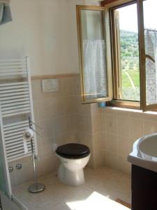een badkamer met een toilet, een wastafel en een raam bij Casa l'Arcobaleno in Montecchio