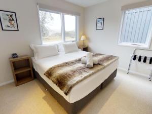 a bedroom with a bed with a faux fur blanket at Family Chalet 33 The Stables Perisher in Perisher Valley
