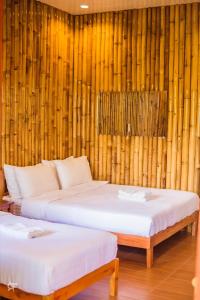 2 letti in una camera con pareti in bambù di Ceazar's Place a Dauin