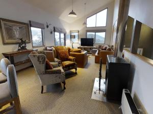 瑞雪谷的住宿－Lodge Chalet 26 - The Stables Perisher，客厅配有沙发、椅子和电视