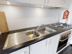 a kitchen with a stainless steel sink and a stove at Apartment 3 The Stables Perisher in Perisher Valley