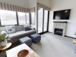 a living room with a couch and a fireplace at Studio Loft 19 - The Stables Perisher in Perisher Valley