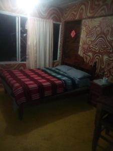 Bett in einem Zimmer mit Fenster in der Unterkunft Hostal mandala Evelyn in El Pacífico