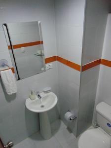 a bathroom with a sink and a toilet and a mirror at Cómodo apartaestudio en Cali para corta o larga estadía in Cali