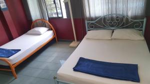 2 letti in una camera con pareti rosse di Mr. Clean Guesthouse a Krabi town