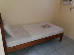 a small bed in a room with a white mattress at Eco Pension in Surigao