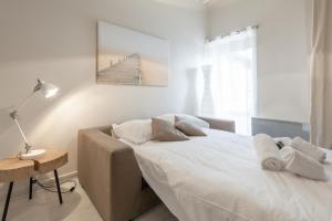 a bedroom with a large white bed and a table at GuestReady - Charming Studio for 2 near the Metro in Lyon