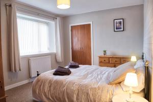 a bedroom with a large bed and a window at North Coast Property - North Coast House in Thurso