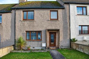 una casa de ladrillo con una puerta y un patio en North Coast Property - North Coast House en Thurso