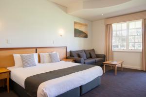 a hotel room with a large bed and a couch at Serafino McLaren Vale in McLaren Vale