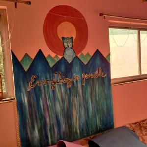 a room with a painting of a cat on the wall at Tebaar Backpackers in Rishīkesh