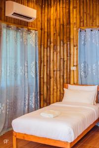 a bed sitting in a room with bamboo at Ceazar's Place in Dauin
