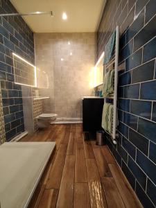 クレルモン・フェランにあるAppartement cosy Parvis Gareの青いタイルのバスルーム(バスタブ、トイレ付)