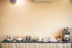 a table with a counter with cups and a coffee maker at The Palm Garden Hotel in Chiang Rai +9 photos