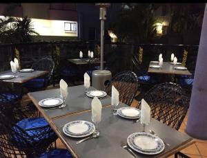 a table with chairs and plates and napkins on it at Asiatic Suite at Nautilus Mooloolaba in Mooloolaba