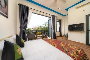 - une chambre avec un grand lit et une grande fenêtre dans l'établissement Ri's House Hoi An Homestay, à Hội An