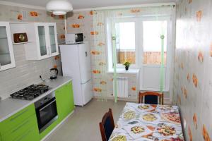 ヨシュカル・オラにあるLuxury Apartment in Yoshkar-Ola (2-rooms)のキッチン(テーブル、白い冷蔵庫付)