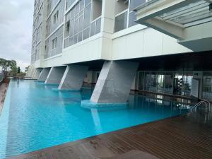 un bâtiment avec une piscine bleue en face dans l'établissement Menteng Park 19th, à Jakarta