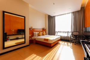 a hotel room with a bed and a large mirror at Paseo Premiere Hotel in Santa Rosa +24 photos