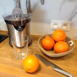 a table with a bowl of oranges and a juicer at 22ndFloor Luxury Suite in Ostend +19 photos