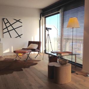 Sala de estar con mesa, silla y cámara en 22ndFloor Luxury Suite, en Ostende