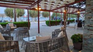 a patio with wicker chairs and tables under a pavilion at Asteri Hotel in Livadi
