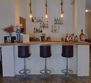 a bar with three bar stools in a room at Asteri Hotel in Livadi
