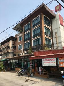 un edificio con una moto parcheggiata di fronte di Baanmali Ari a Pathum Thani