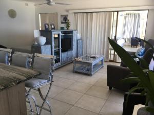 a living room with a couch and a television at Dream a Little in Simonʼs Town