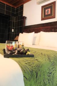 uma bandeja de comida numa cama num quarto de hotel em Misty Hills Country Hotel, Conference Centre & Spa em Muldersdrift