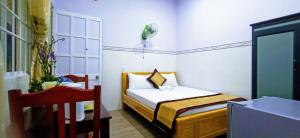 1 dormitorio pequeño con 1 cama y 1 silla en Duong Hieu Guesthouse, en Phu Quoc