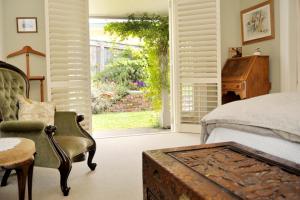 ein Schlafzimmer mit einem Bett, einem Stuhl und einem Klavier in der Unterkunft Kippilaw House in Picton