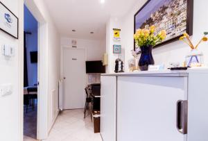 een woonkamer met een vaas met bloemen op een toonbank bij "6 in centro" guest house in Sanremo
