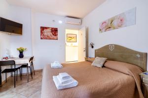 1 dormitorio con 1 cama con toallas en "6 in centro" guest house, en San Remo