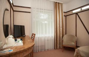a room with a desk with a television and a window at Park Hotel Mechta in Oryol