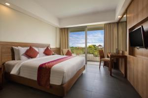a hotel room with a bed and a balcony at Paragon Hotel Seminyak in Seminyak
