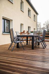 una terraza de madera con mesa de picnic y 2 sillas en Heide-Trail Dolle en Dolle