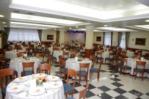 einen Bankettsaal mit weißen Tischen und Stühlen in der Unterkunft Hotel Castelmonardo in Filadelfia