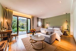 Hotel Del Moon في يانغتشو: غرفة نوم بها سرير وأريكة وطاولة +65 صورة