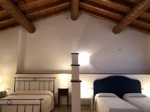 two beds in a room with wooden ceilings at Agriturismo Bitturelli in Ponti Sul Mincio
