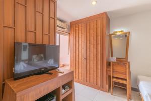 uma sala de estar com uma televisão de ecrã plano num quarto em Lotus Hotel Patong em Praia de Patong