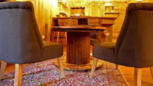 Duas cadeiras e uma mesa de madeira num quarto em Dada Mountain Hotel em Morgex